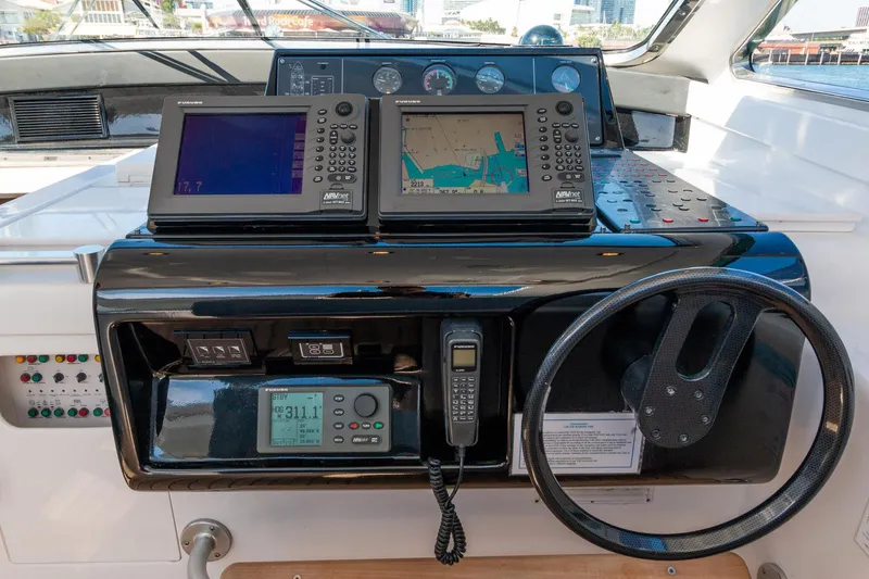 Slide: The Image of Control panel of a 2007 Leopard Express Motor Yacht with navigation equipment and steering wheel. - 19