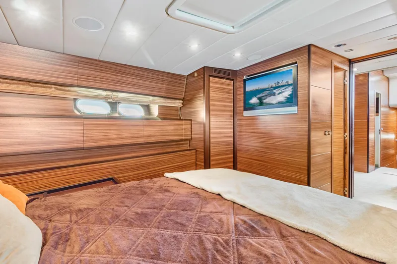 Slide: The Image of Luxurious 2007 Leopard Express Motor Yacht bedroom with wood paneling and modern decor. - 22