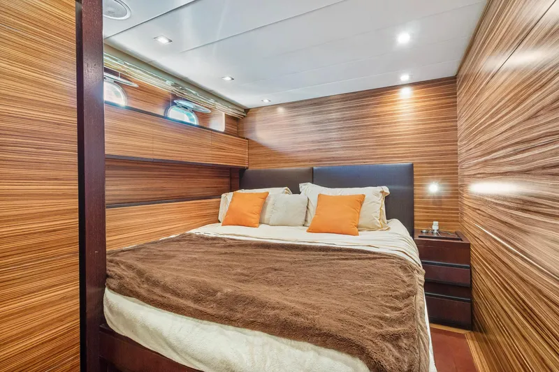 Slide: The Image of Luxurious bedroom interior on 2007 Leopard Express Motor Yacht with wood paneling and cozy bedding. - 26