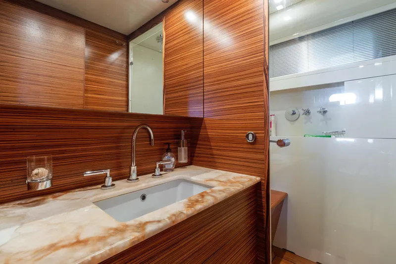 Slide: The Image of Luxurious bathroom in 2007 Leopard Express Motor Yacht with wood paneling and marble countertop. - 27
