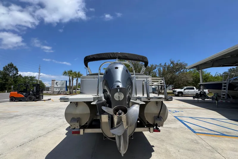 Slide: The Image of 2021 Avalon LSZ 2485 QL pontoon boat parked outdoors under clear blue sky. - 14