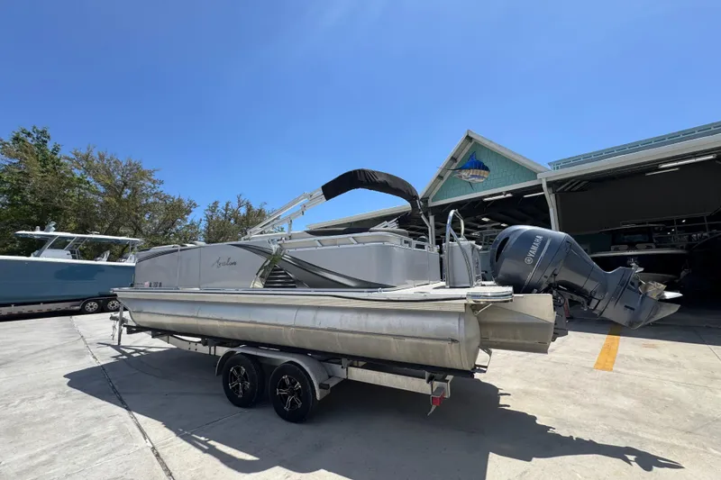 Slide: The Image of 2021 Avalon LSZ 2485 QL pontoon boat on trailer, parked outdoors. - 17