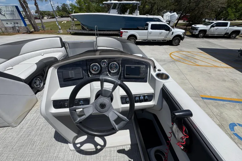 Slide: The Image of Cockpit view of 2021 Avalon LSZ 2485 QL boat with steering wheel and dashboard controls. - 25