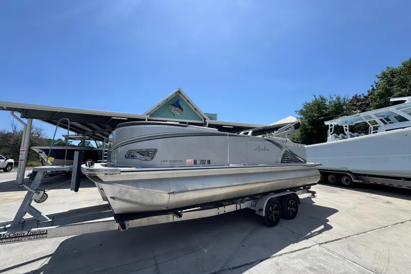 Slide: The Image of 2021 Avalon LSZ 2485 QL pontoon boat on trailer under clear blue sky. - 3