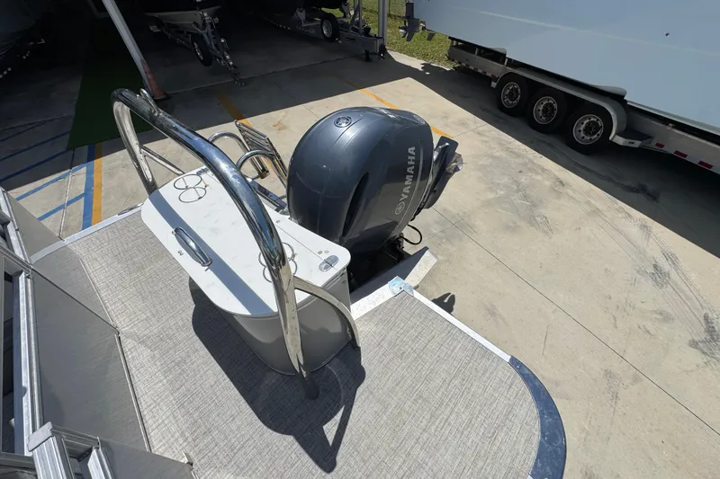 Slide: The Image of 2021 Avalon LSZ 2485 QL pontoon boat with Yamaha outboard motor in a parking area. - 31