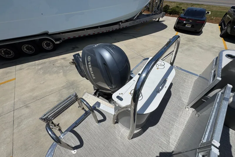 Slide: The Image of 2021 Avalon LSZ 2485 QL pontoon boat with Yamaha outboard motor in a parking lot. - 32