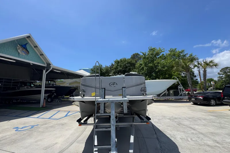 Slide: The Image of 2021 Avalon LSZ 2485 QL pontoon boat on trailer at marina under clear blue sky. - 6