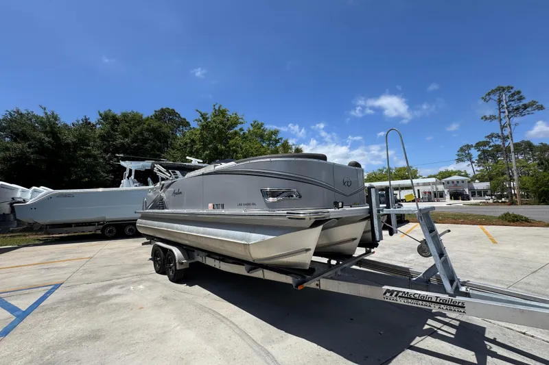 Slide: The Image of 2021 Avalon LSZ 2485 QL pontoon boat on trailer under clear blue sky. - 8