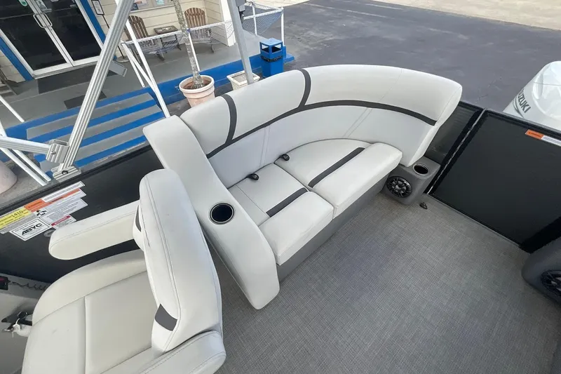 Slide: The Image of 2023 Crest Classic LX 200 SLC boat interior with white seating and cup holders. - 10