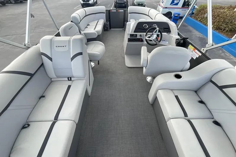 Slide: The Image of 2023 Crest Classic LX 200 SLC pontoon boat interior with gray seating and steering console. - 12