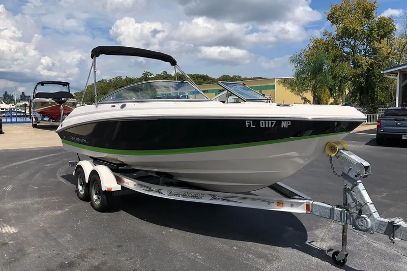 Slide: The Image of 2008 Regal 2000 Bowrider boat on trailer, parked outdoors under a partly cloudy sky. - 4