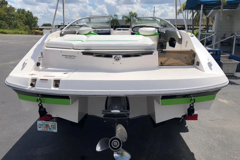 Slide: The Image of 2008 Regal 2000 Bowrider boat, rear view, parked on pavement under a cloudy sky. - 7