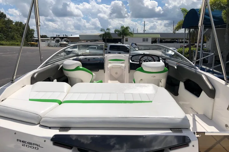 Slide: The Image of 2008 Regal 2000 Bowrider boat with white and green seating, parked outdoors. - 8