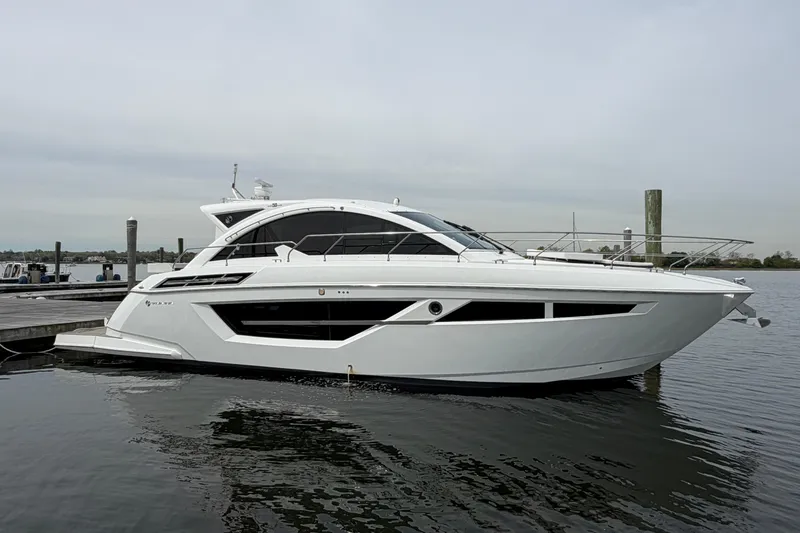 The Image of 2018 Cruisers Yachts 50 Cantius luxury boat docked on calm water. - 0