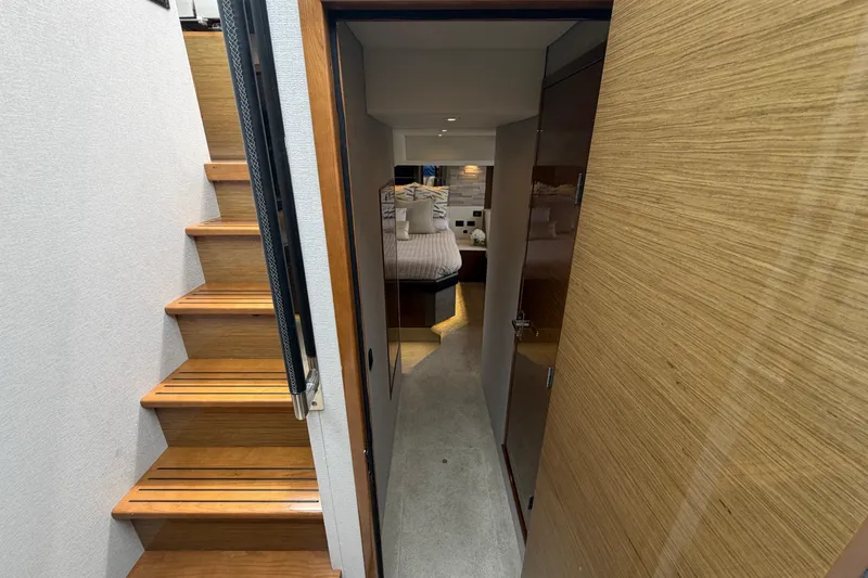 Slide: The Image of Interior view of 2018 Cruisers Yachts 50 Cantius, featuring wooden stairs and cozy bedroom. - 31