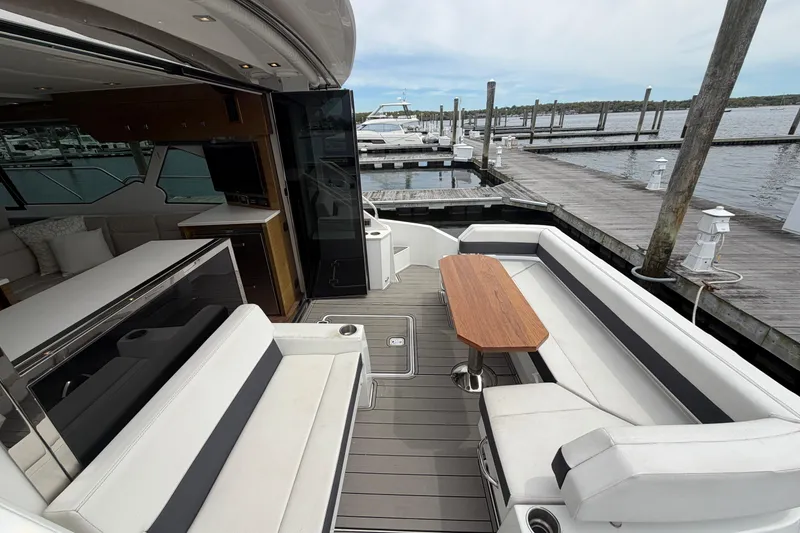 Slide: The Image of Luxurious 2018 Cruisers Yachts 50 Cantius with elegant seating and wooden table at marina. - 4
