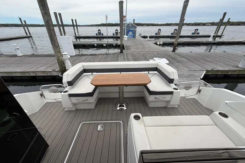 Slide: The Image of 2018 Cruisers Yachts 50 Cantius cockpit with seating and table, docked by the water. - 52