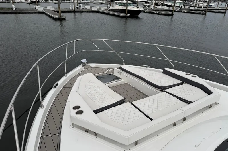 Slide: The Image of Bow seating area on 2018 Cruisers Yachts 50 Cantius, docked in a marina. - 55