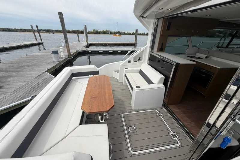 Slide: The Image of 2018 Cruisers Yachts 50 Cantius with elegant deck seating and modern interior at a marina. - 7