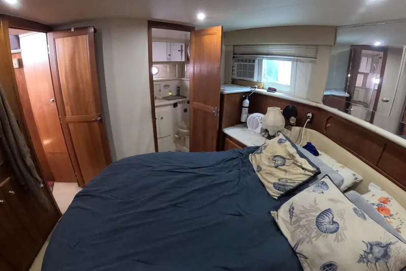 Slide: The Image of Interior of 2000 Carver 406 Motor Yacht bedroom with cozy bedding and wooden cabinetry. - 10