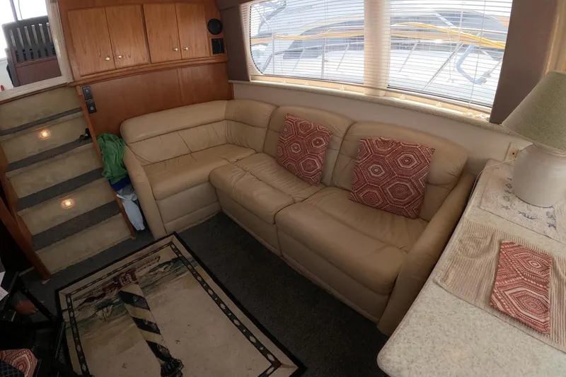 Slide: The Image of Interior of 2000 Carver 406 Motor Yacht with beige leather sofa and decorative pillows. - 15