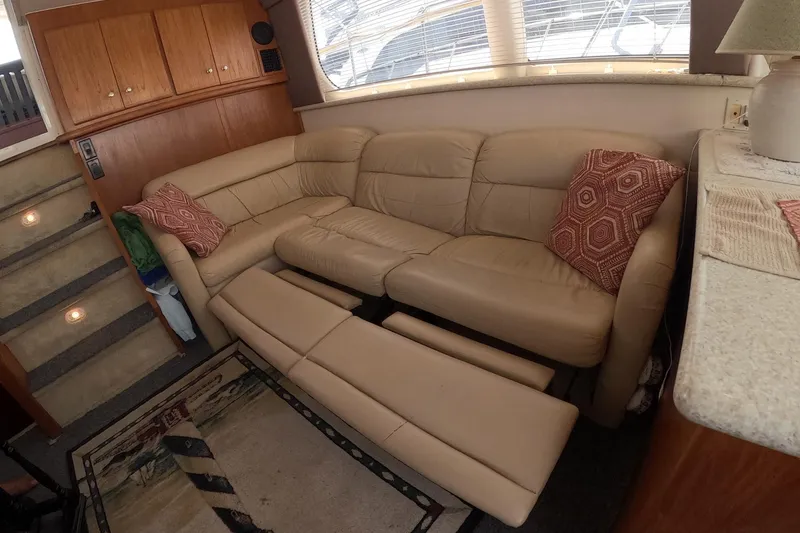 Slide: The Image of Interior of 2000 Carver 406 Motor Yacht with beige leather sofa and decorative pillows. - 16