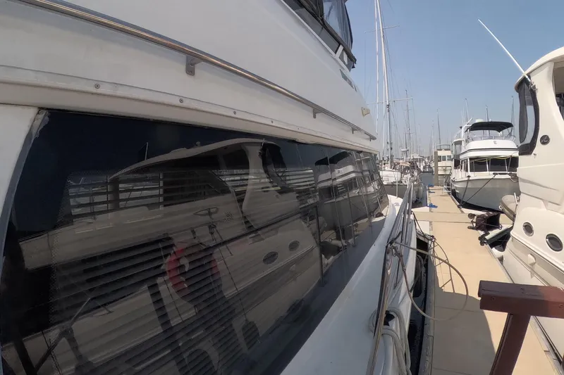 Slide: The Image of 2000 Carver 406 Motor Yacht docked at marina, side view with reflections. - 19