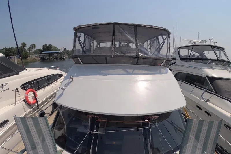 Slide: The Image of 2000 Carver 406 Motor Yacht docked between other boats on a sunny day. - 22