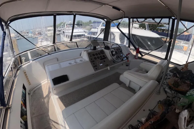Slide: The Image of Interior view of a 2000 Carver 406 Motor Yacht cockpit with marina background. - 23