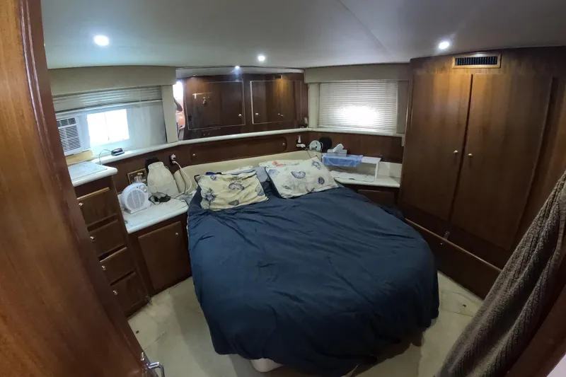 Slide: The Image of Cozy bedroom in 2000 Carver 406 Motor Yacht with wood cabinetry and blue bedding. - 9