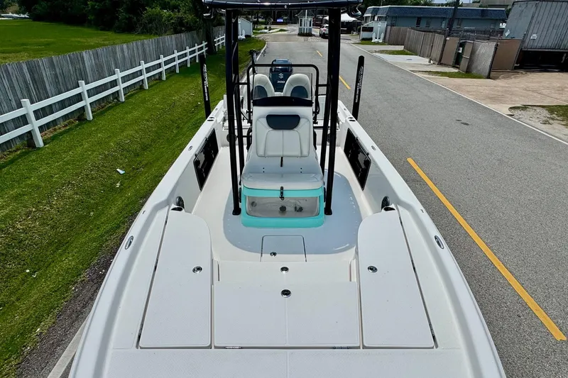 Slide: The Image of 2017 Blue Wave 2400 PureBay boat on road, showcasing spacious deck and seating. - 15