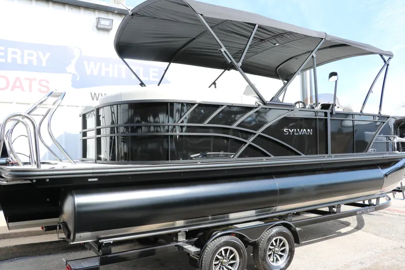 Slide: The Image of 2025 Sylvan Mirage X3 pontoon boat with canopy on trailer, side view. - 2