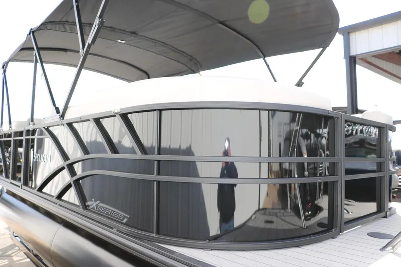 Slide: The Image of 2025 Sylvan Mirage X3 pontoon boat with sleek black design and canopy. - 3