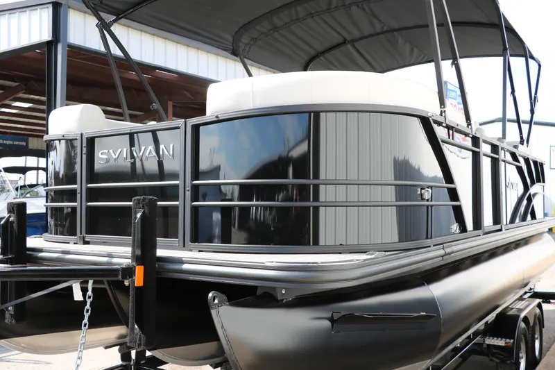 Slide: The Image of 2025 Sylvan Mirage X3 pontoon boat with sleek black exterior and canopy. - 5