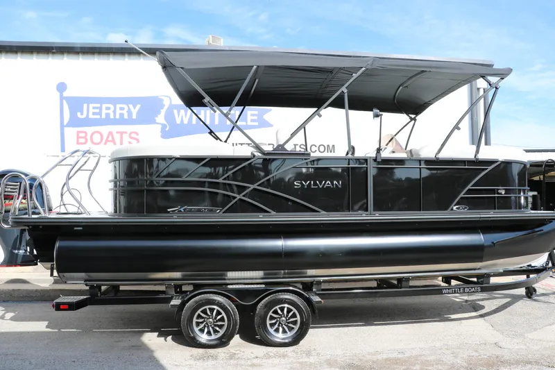 Slide: The Image of 2025 Sylvan Mirage X3 pontoon boat with canopy on trailer, displayed outdoors. - 8