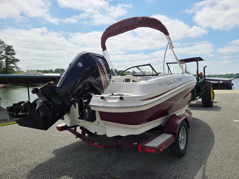 Slide: The Image of 2016 Tahoe 450 TS boat on trailer by lakeside. - 2
