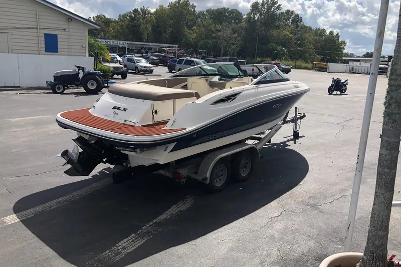 The Image of 2012 Sea Ray 210 SLX boat on trailer in parking lot, sunny day. - 0