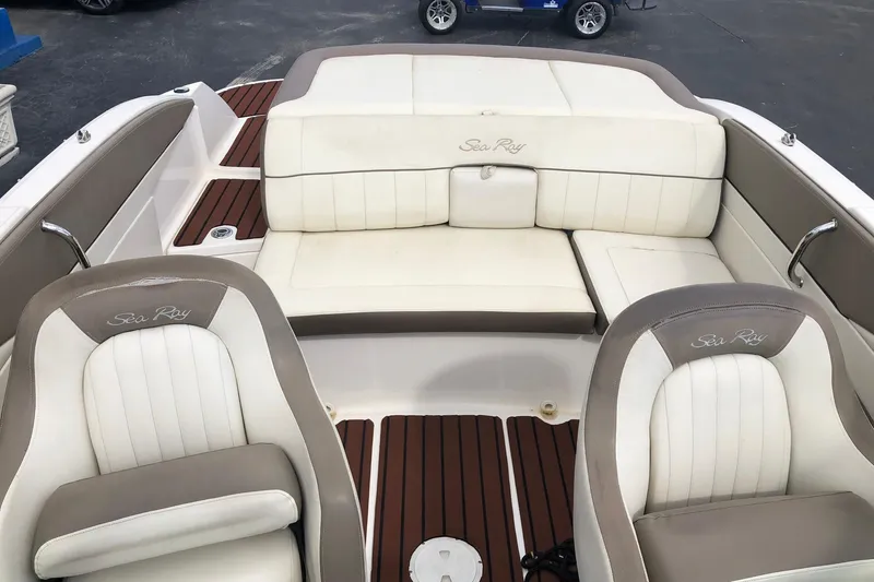 Slide: The Image of 2012 Sea Ray 210 SLX boat interior with white and beige seating, wood accents. - 14