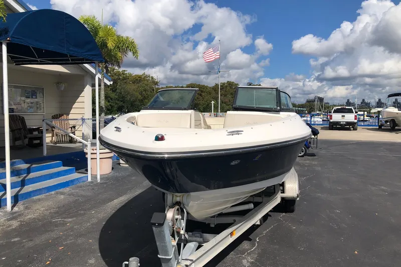 Slide: The Image of 2012 Sea Ray 210 SLX boat on trailer, parked outdoors under a cloudy sky. - 2