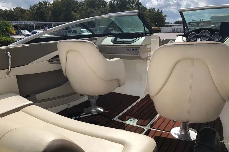 Slide: The Image of Interior of a 2012 Sea Ray 210 SLX boat with beige seating and wood flooring. - 4