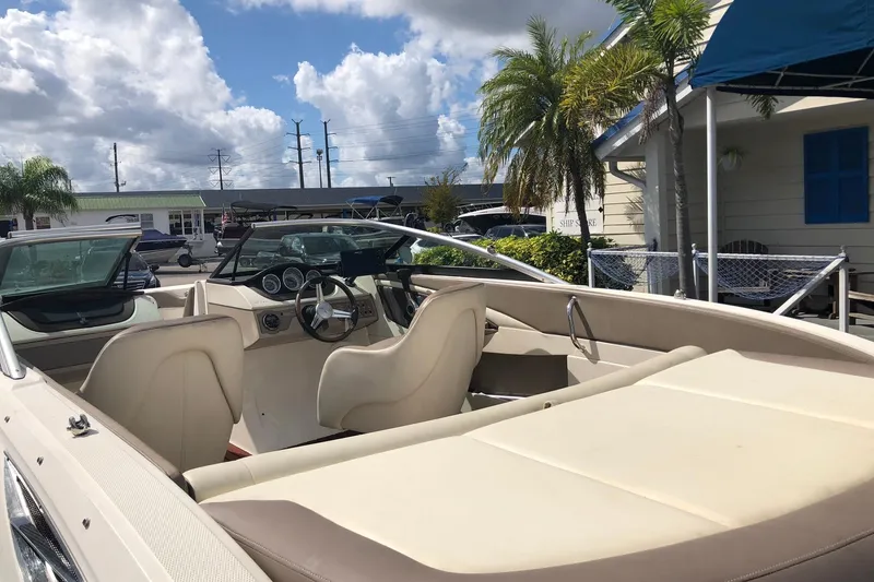 Slide: The Image of 2012 Sea Ray 210 SLX boat interior with steering wheel, seats, and dashboard under a cloudy sky. - 5