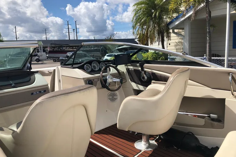 Slide: The Image of Interior of a 2012 Sea Ray 210 SLX boat with beige seating and dashboard. - 6