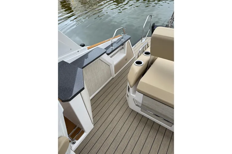 Slide: The Image of Balise Helix 26 L 2025 boat interior with beige seating and sleek countertops. - 21