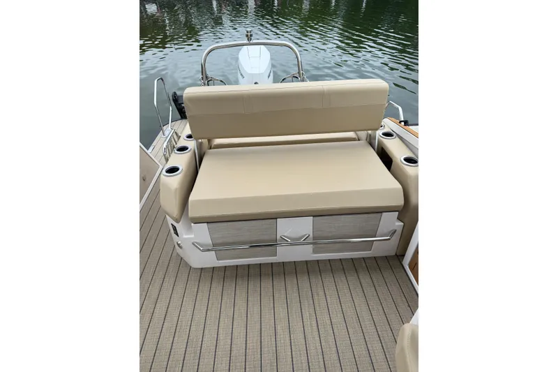Slide: The Image of 2025 Balise Helix 26 L boat seating area with beige cushions and cup holders. - 23