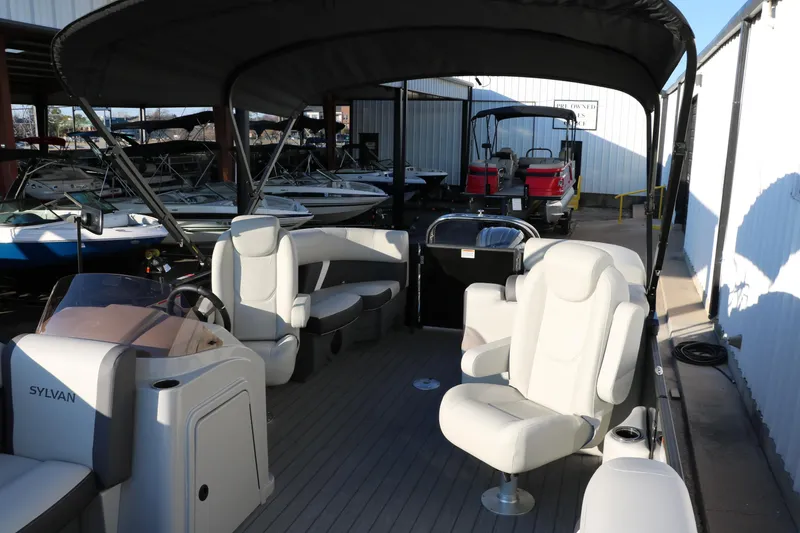 Slide: The Image of 2025 Sylvan Mirage X1 pontoon boat with spacious seating and canopy in a marina setting. - 16