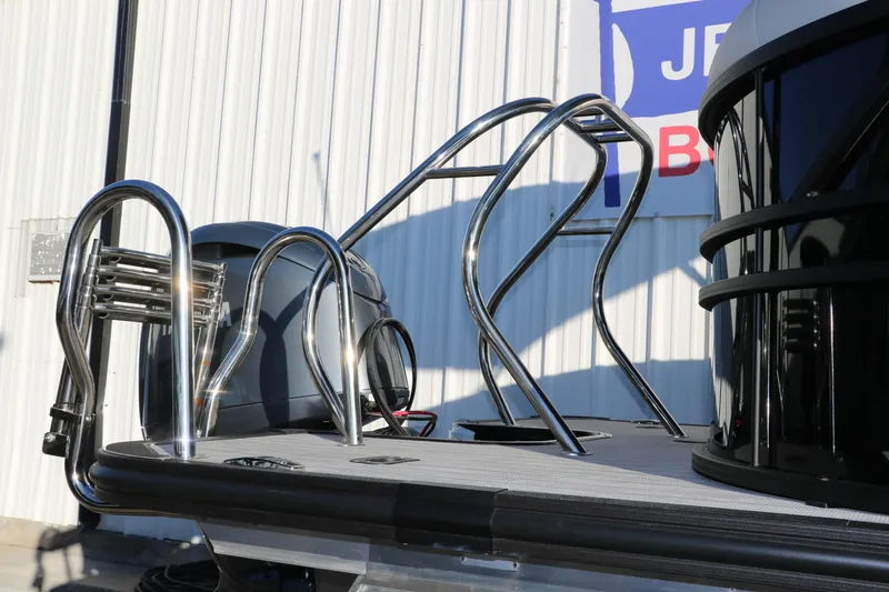 Slide: The Image of 2025 Sylvan Mirage X1 boat with stainless steel railings and motor, docked near a building. - 11
