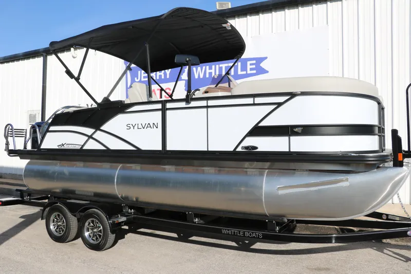 The Image of 2025 Sylvan Mirage X X1 CLZ DH pontoon boat on trailer, parked outside dealership. - 0