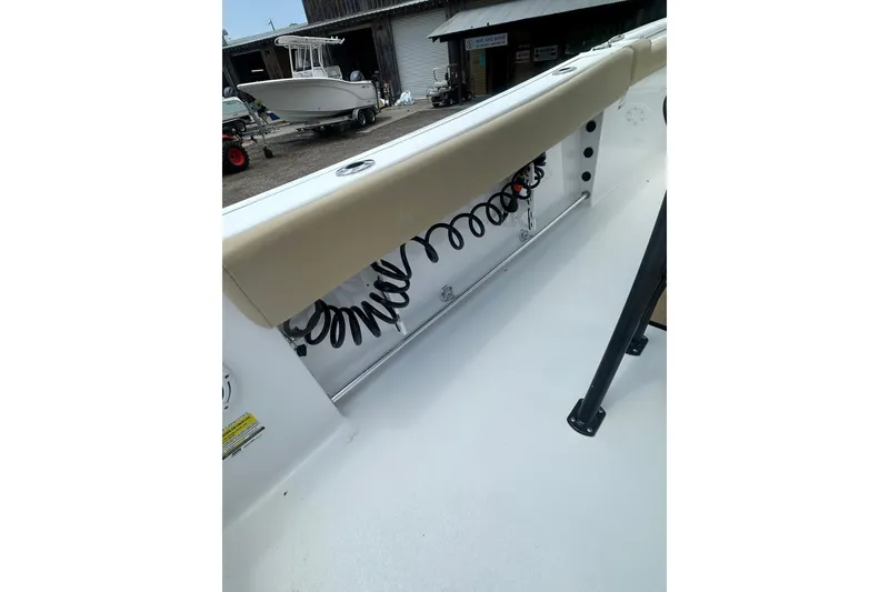 Slide: The Image of 2026 Sportsman Open 232 Center Console boat interior with coiled hose and cushioned seating. - 17