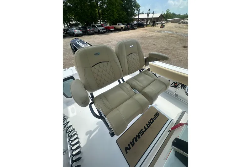 Slide: The Image of 2026 Sportsman Open 232 Center Console boat seats, beige leather, outdoor setting. - 21