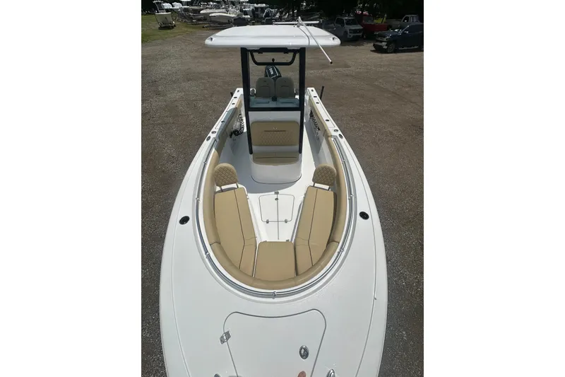 Slide: The Image of 2026 Sportsman Open 232 Center Console boat with tan seating, parked outdoors. - 38